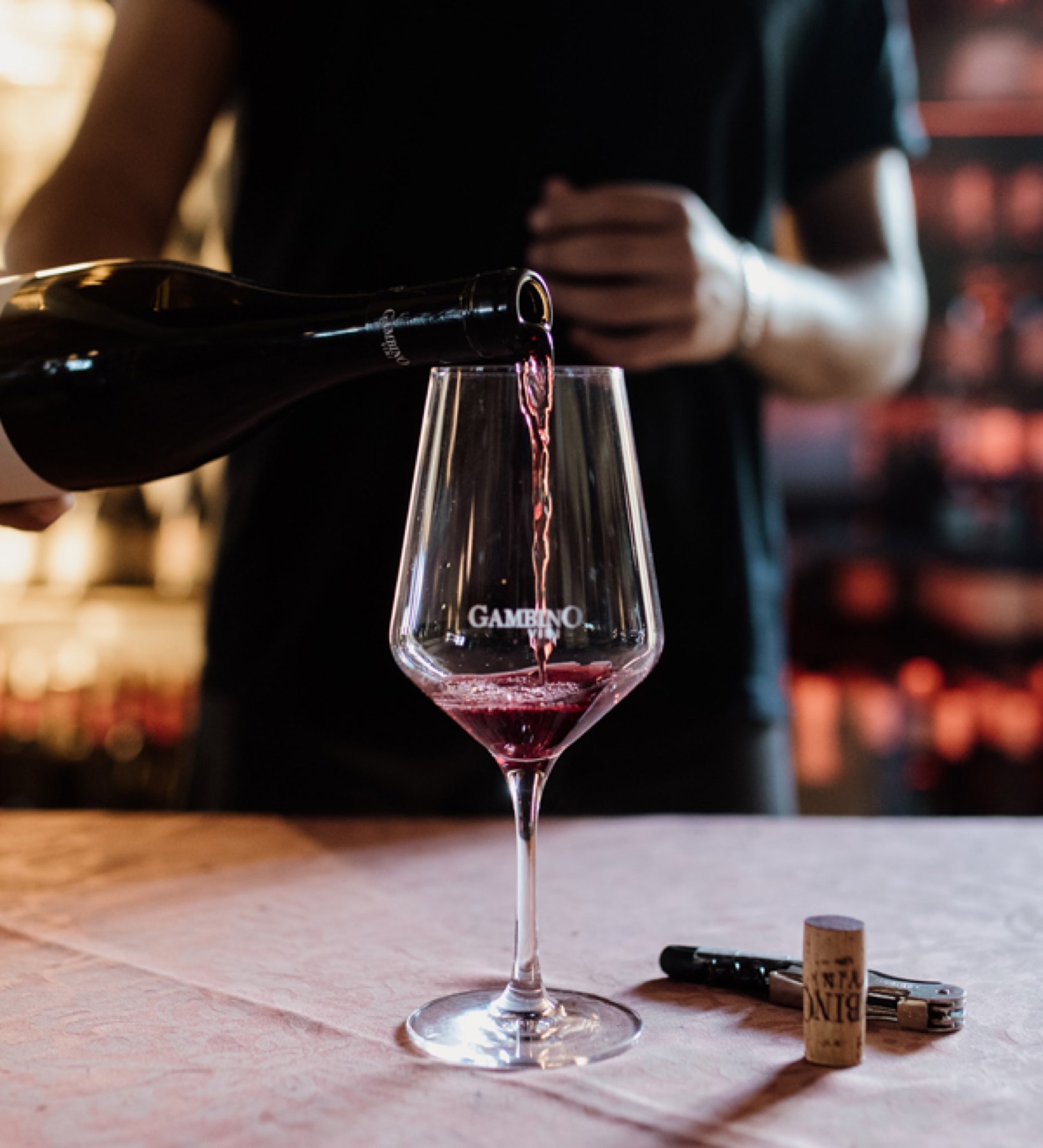 Un sommelier versa il vino rosso nel calice