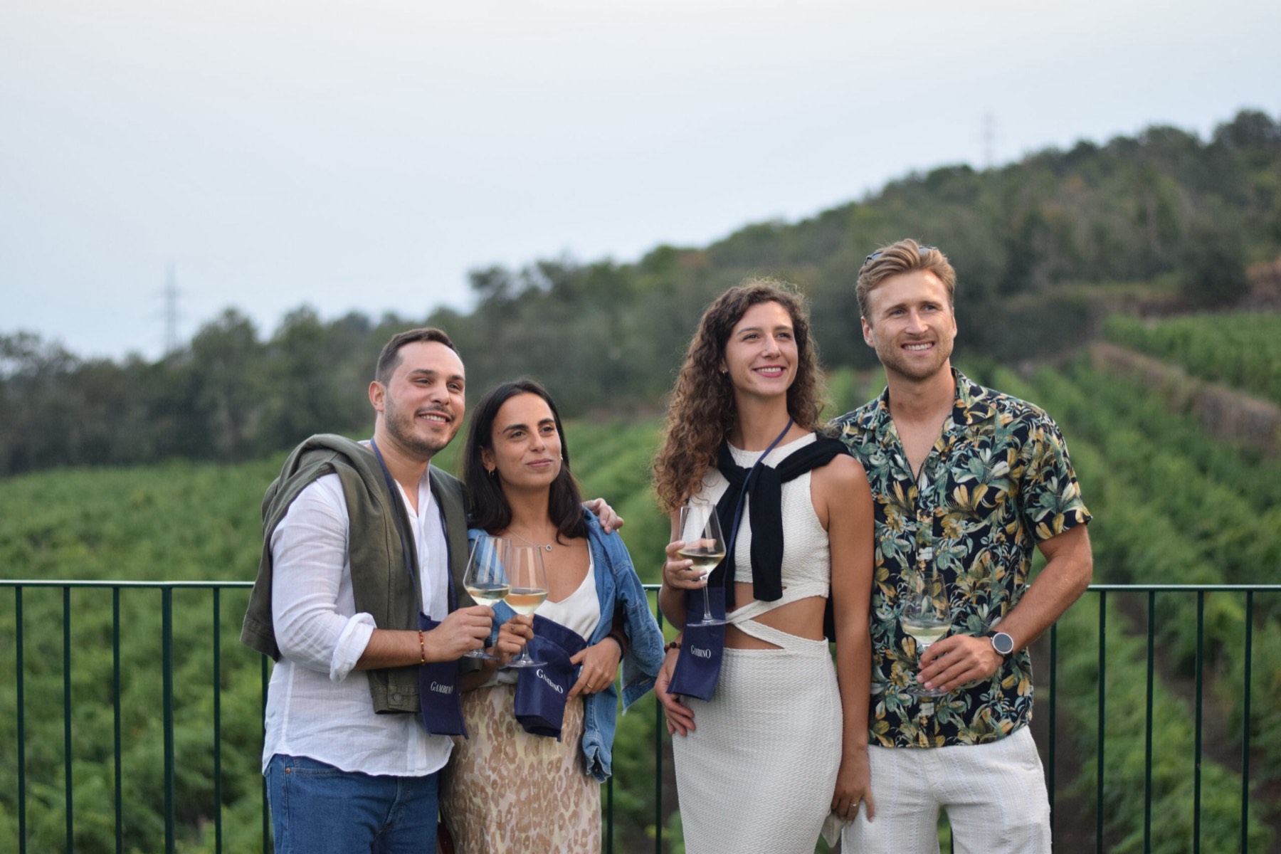 Un gruppo di ospiti con i calici sulla terrazza affacciata sui vigneti